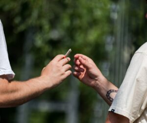 two hands passing a honeycrisp joint