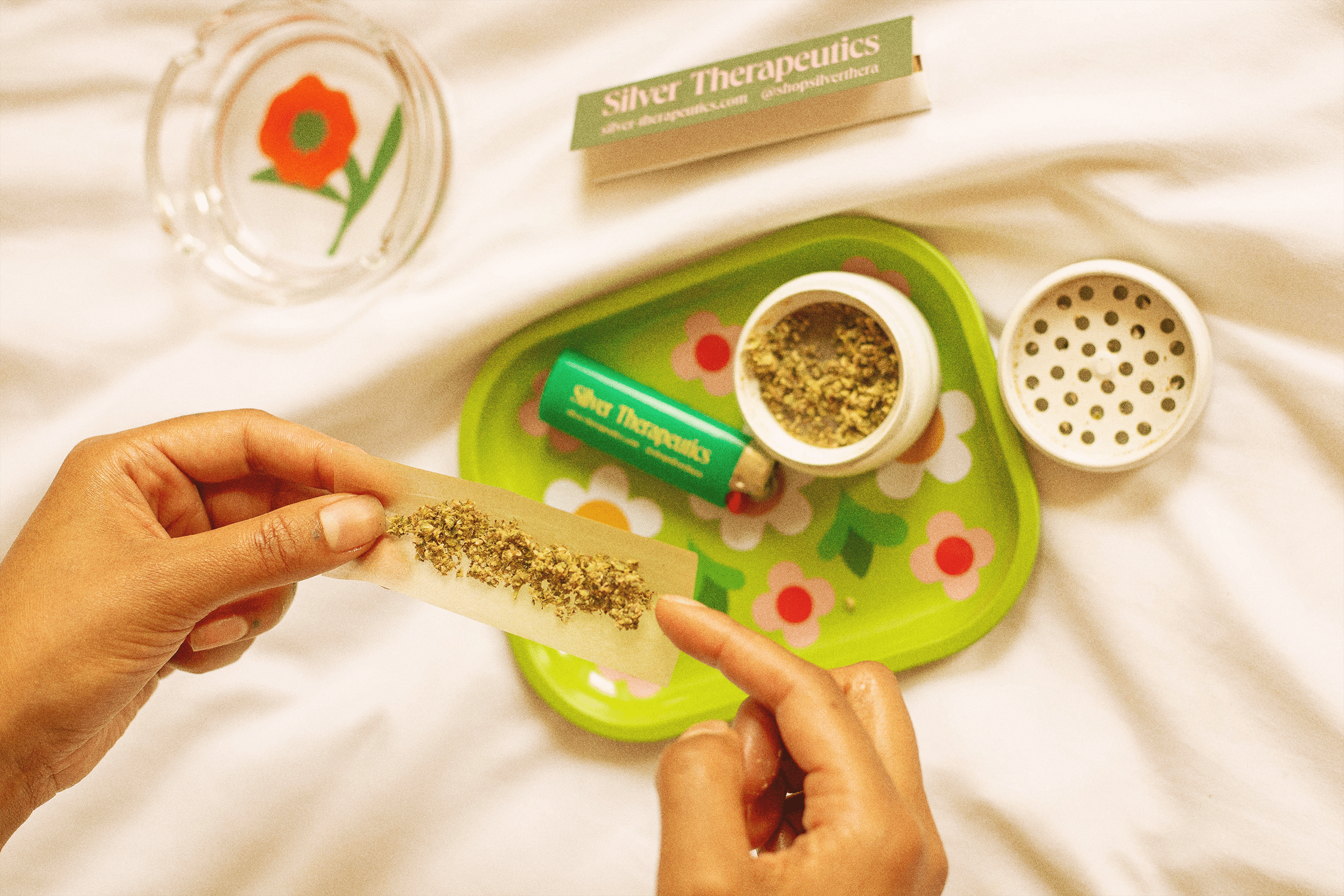 rolling a joint on a silver branded rolling stray