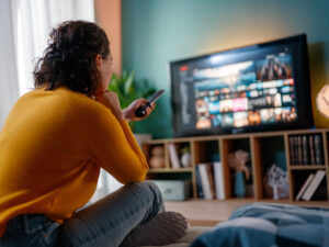 Happy woman watching TV at home.