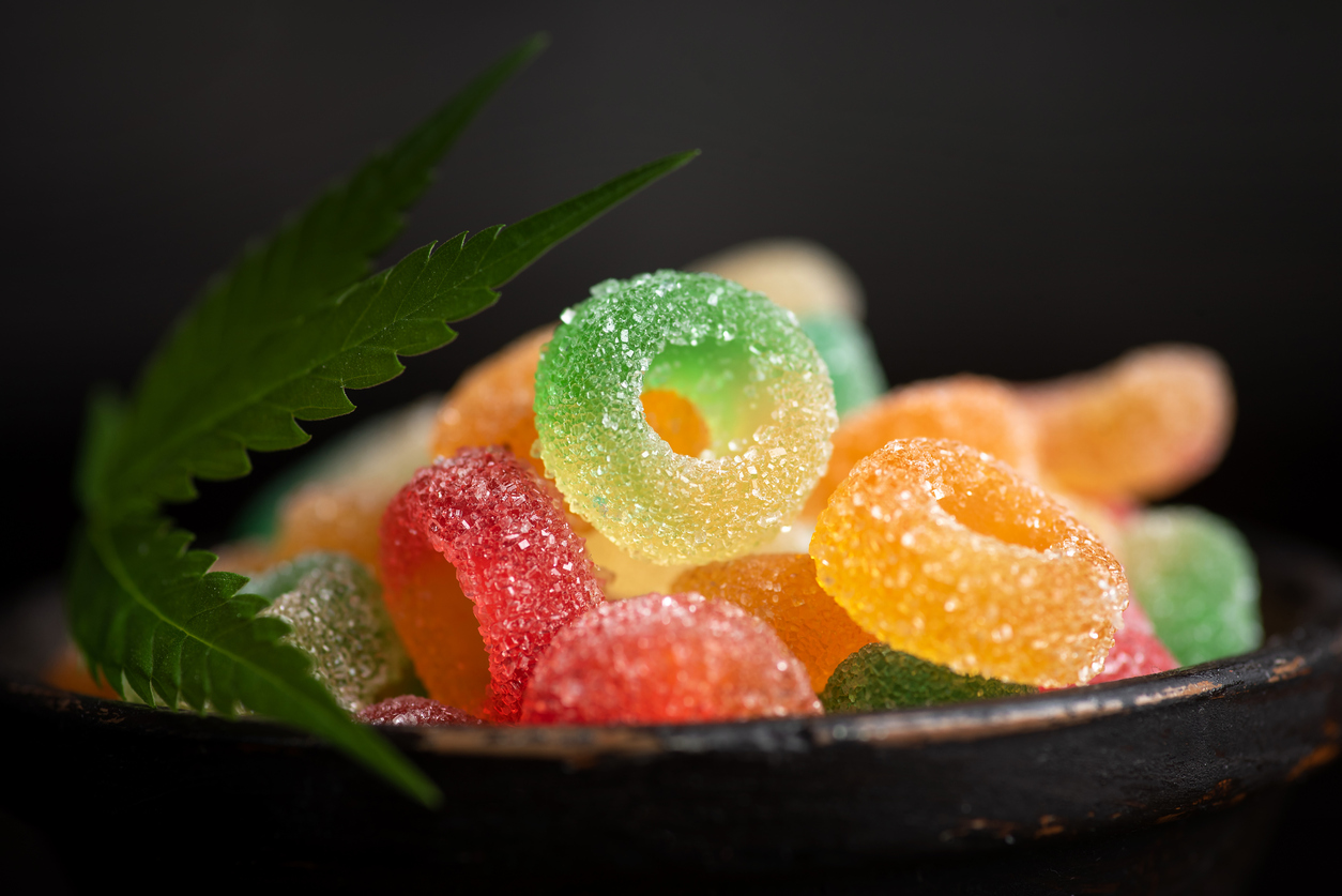 Colored candy gelatin in a black bowl with marijuana leaves