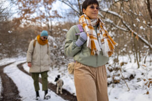 Caucasian couple hiking during winter day while dog makes them a company