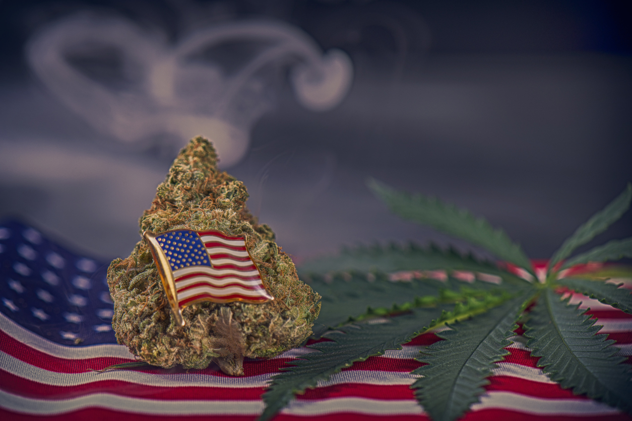 Cannabis bud, leaf and american flag with smoke and copyspace - veteran theme medical marijuana concept