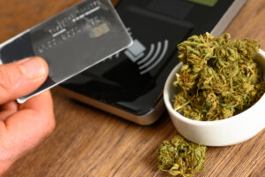 Paying by credit card for marijuana at a cannabis dispensary. Purchasing legal recreation drugs. Medical marijuana at a clinic.