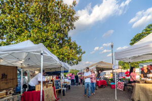 Tucker, Georgia, USA - May 22, 2014: Shoppers walk down the main vendor aisle during the Tucker Farmers Market in downtown Tucker, Georgia.