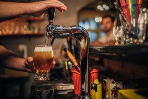 Glass of beer with barrel, bottle and fresh hops