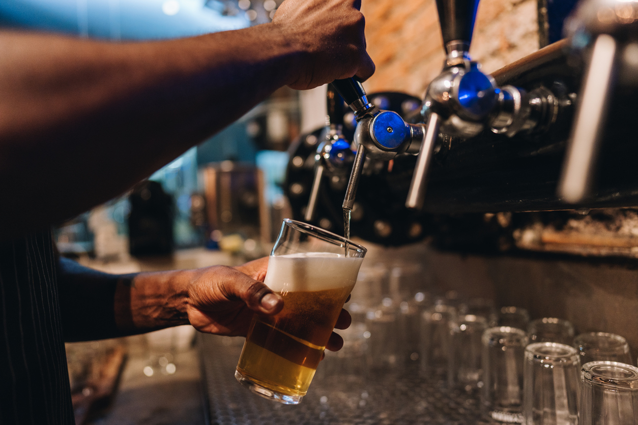 Close-up of a bartender pouring a draught lager beer